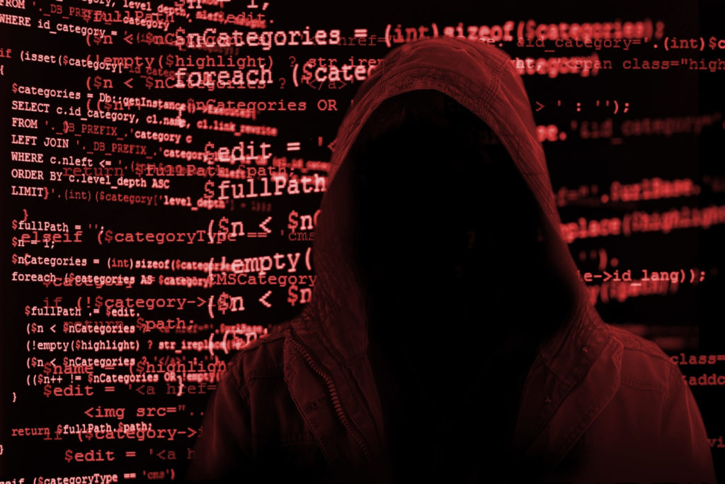 hooded figure looking at computer code