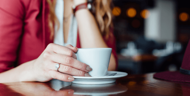 a person holding a cup of coffee