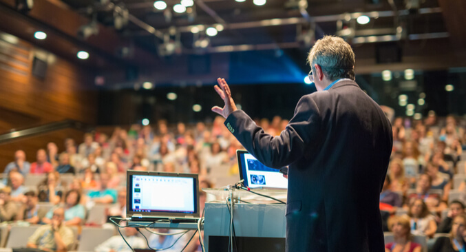 a man holding a microphone in front of a crowd