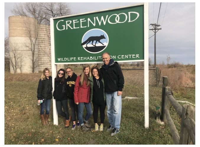 a group of people posing for a photo next to a sign