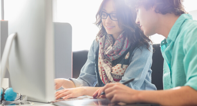 a woman and a man looking at a computer screen