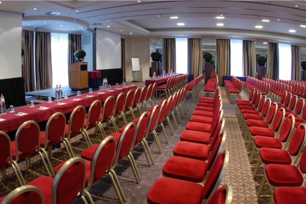 a room with red chairs and a stage