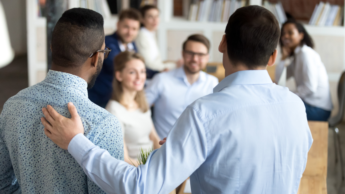 group of people, one person is patting the other on the back