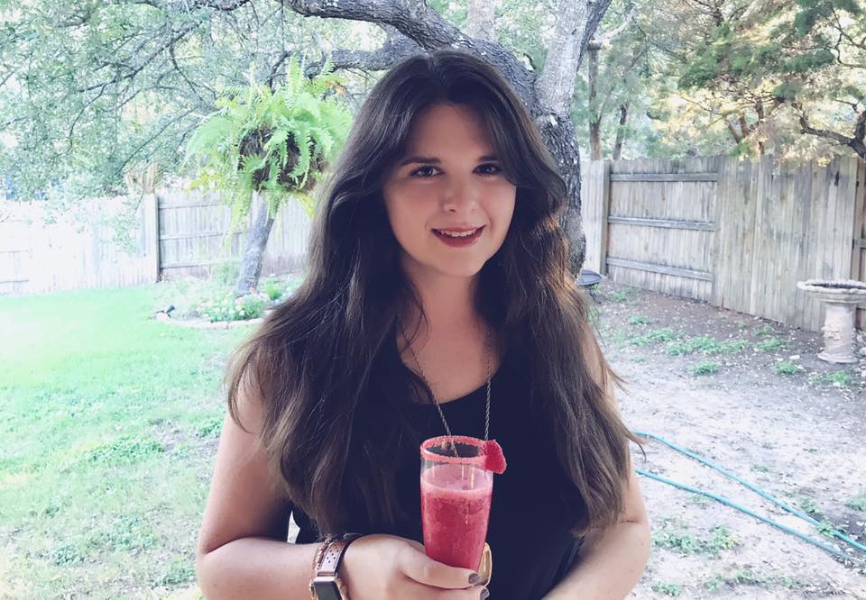 a woman holding a drink