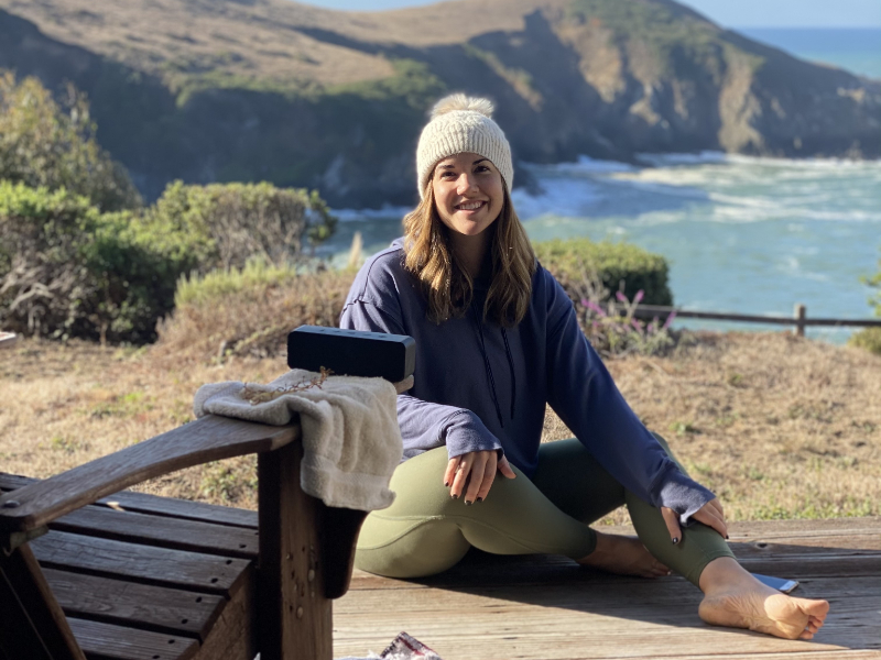 a person sitting on a patio with an ocean view in the background