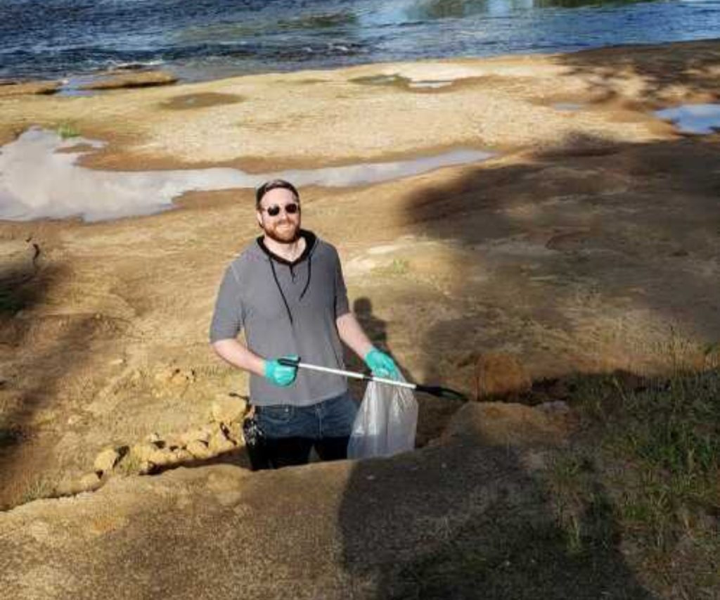 a person holding a tool to pick up trash on a beach